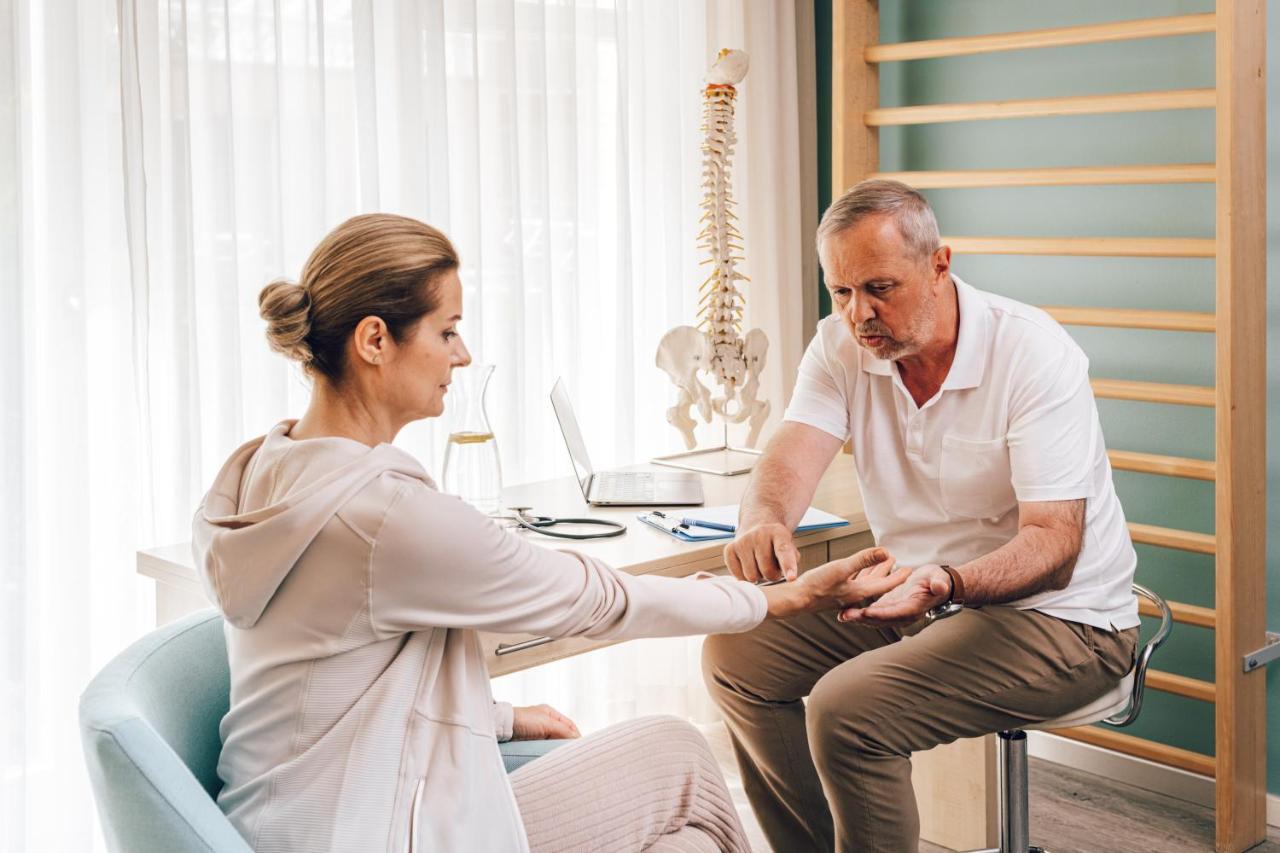 Falkensteiner Spa Resort Marianske Lazne Luaran gambar A chiropractor examines a patient's wrist